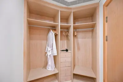 a walk in closet with wooden shelves and a dresser at Elegant Private Room at The Palm with Beach & Pool Access in Dubai