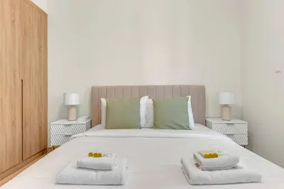 a bedroom with a large white bed with towels on it at Canal View, Partial Burj Khalifa View, Brand New in Dubai