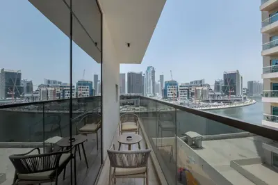 a balcony with chairs and tables and a view of the city at Canal View, Partial Burj Khalifa View, Brand New in Dubai