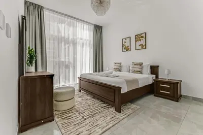 a bedroom with a bed and a large window at stylish 1BR Pearlz Pool & Gym Near Metro in Dubai