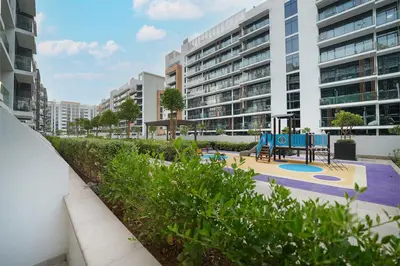 a playground in an apartment complex with buildings at EasyGo- Spacious, Low Floor and Pool view STU in Dubai