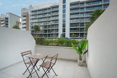 a table and chairs on a balcony with a building at EasyGo- Spacious, Low Floor and Pool view STU in Dubai