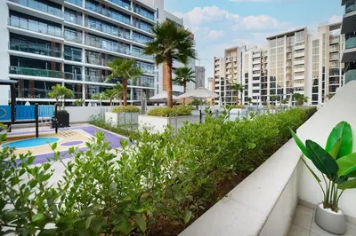 a view of the courtyard of a building with palm trees at EasyGo- Spacious, Low Floor and Pool view STU in Dubai
