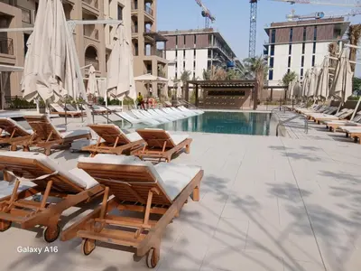 a group of lounge chairs and a swimming pool at Madinat Jumeirah Living 1 Bedroom Holiday Rental in Jadeel 3 - DVH Holiday Homes in Dubai