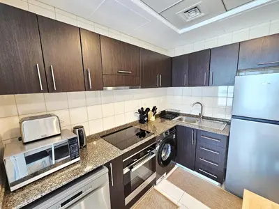 a kitchen with a refrigerator microwave and a dishwasher at Opposite JBR Beach - Modern Studio in Dubai