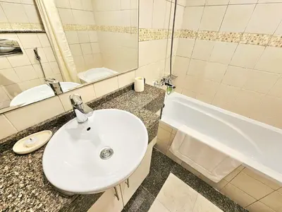 a bathroom with a sink and a toilet and a tub at Opposite JBR Beach - Modern Studio in Dubai