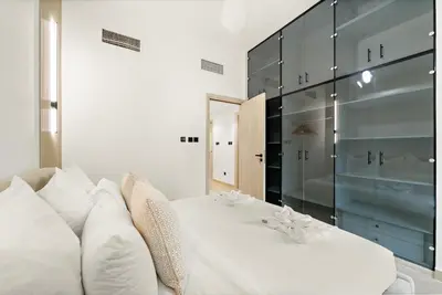 a bedroom with a white bed and a glass wall at Luxury 5BR Penthouse in Marina l Private Jacuzzi & Sauna in Dubai