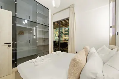 a bedroom with a white bed and a glass wall at Luxury 5BR Penthouse in Marina l Private Jacuzzi & Sauna in Dubai