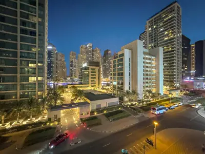 a city skyline at night with cars and buildings at Luxury 5BR Penthouse in Marina l Private Jacuzzi & Sauna in Dubai