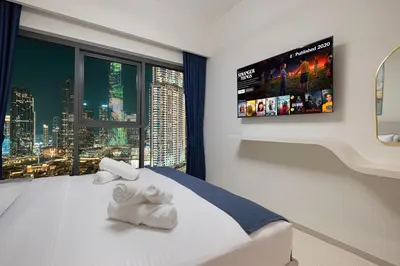 a bedroom with a bed with a tv on the wall at Burj Royale Luxury 2BR Burj Khalifa & Fountain View 5 Min Walk Dubai Mall, 500MBPS Wifi in Dubai