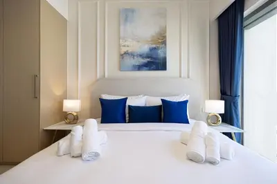 a bedroom with a white bed with towels on it at Burj Royale Luxury 2BR Burj Khalifa & Fountain View 5 Min Walk Dubai Mall, 500MBPS Wifi in Dubai
