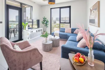a living room with a blue couch and some chairs at Frank Porter - Hyati Avenue in Dubai
