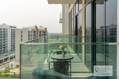 a glass balcony with a table on a building at Cozy Apartments in Azizi Riviera Dubai in Dubai