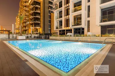 a large swimming pool in the middle of a building at Cozy Apartments in Azizi Riviera Dubai in Dubai
