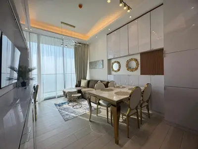 a living room with a table and a couch at Stylish 1BR Skyline Views JVC Dubai in Dubai