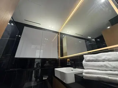 a bathroom with a sink and a mirror and towels at Stylish 1BR Skyline Views JVC Dubai in Dubai