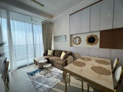 a living room with a table and a couch at Stylish 1BR Skyline Views JVC Dubai in Dubai