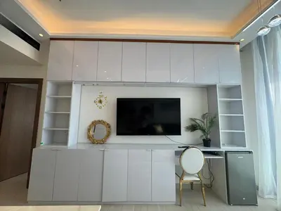 a living room with a tv on a white wall at Stylish 1BR Skyline Views JVC Dubai in Dubai