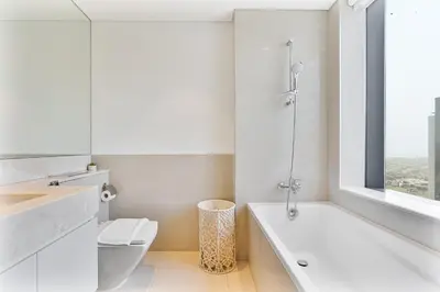 a white bathroom with a tub and a toilet at Amazing 3BR APT Near Burj Khalifa and Dubai Mall in Dubai