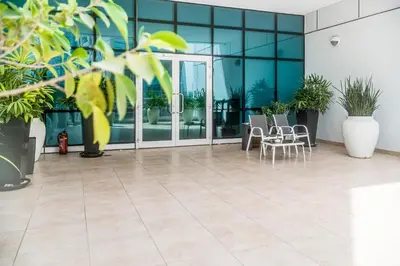 an empty lobby with tables and chairs and windows at MAG218 Cozy 1BHK Near Marina Walk in Dubai