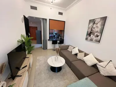 a living room with a couch and a table at Cozy 1BR apartment in Marina in Dubai