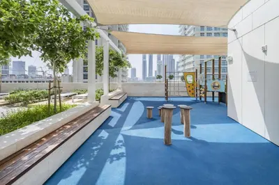 a view of a building with benches and a playground at Sea View 2B Beachfront Luxury Emaar Beachfront in Dubai