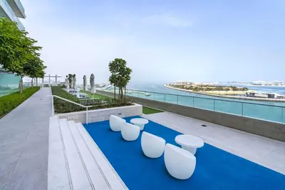a row of white stools sitting on a blue carpet at Sea View 2B Beachfront Luxury Emaar Beachfront in Dubai