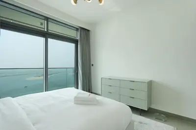 a bedroom with a white bed and a large window at Sea and Palm View 2B Beachfront Luxury Emaar Beachfront in Dubai
