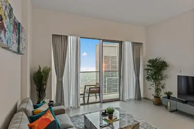 a living room with a couch and a large window at Luxury 2BR at Signature Grande - Next to Dubai Mall & Burj Khalifa in Dubai