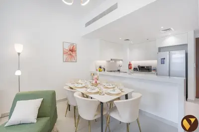 a white dining room with a table and chairs at Vogue Madinat Jumeirah Living Jadeel near Burj AlArab, Two-Bedroom Apartment with Large Balcony and Pool View, Access to All Amenities in Dubai