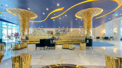a lobby with gold columns and couches and chairs at Stunning Bay View Studio in Center of Dubai in Dubai