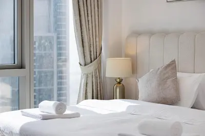 a bedroom with a white bed with a window at Luxury 2BR Sea Burj views Khalifa infinity pool in Dubai