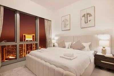 a white bedroom with a large bed and a window at Luxury 2BR Sea Burj views Khalifa infinity pool in Dubai