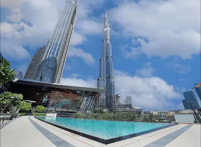 a swimming pool in front of a city with tall buildings at Luxury 2BR Sea Burj views Khalifa infinity pool in Dubai