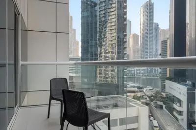 a balcony with two chairs and a view of a city at FIRST CLASS 1BR Luxury Meets Simplicity in Dubai