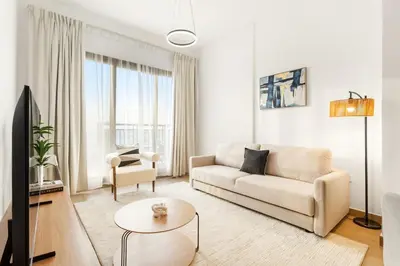 a living room with a couch and a table at FIRST CLASS 1BR Modern with Tranquil Touch in Dubai