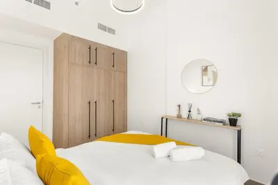 a bedroom with a bed with a yellow blanket at FIRST CLASS 1BR Modern with Tranquil Touch in Dubai