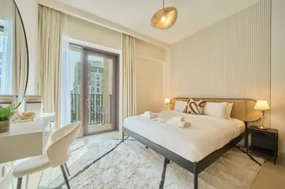 a bedroom with a bed and a desk and a window at Chic & Sunny 1BR Escape At Grove Creek Beach Access in Dubai