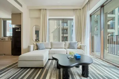 a living room with a couch and a table at Chic & Sunny 1BR Escape At Grove Creek Beach Access in Dubai