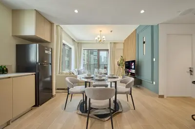 a kitchen and dining room with a table and chairs at Chic & Sunny 1BR Escape At Grove Creek Beach Access in Dubai