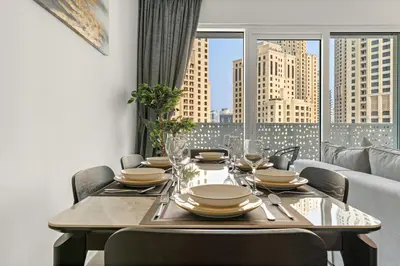 a dining room table with chairs and a large window at FIRST CLASS 1BR Stylish Beachfront Escape in Dubai