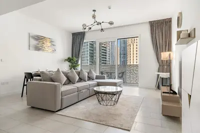 a living room with a couch and a table at FIRST CLASS 1BR Stylish Beachfront Escape in Dubai