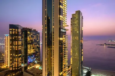 a group of tall buildings in a city at night at FIRST CLASS 3BR Sea View Near JBR Beach in Dubai