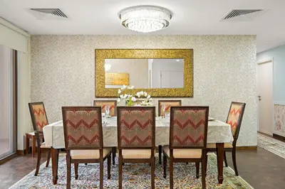a dining room with a table with chairs and a mirror at FIRST CLASS 3BR Sea View Near JBR Beach in Dubai