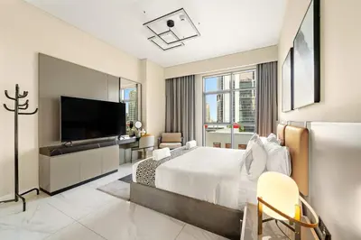 a bedroom with a bed and a flat screen tv at FIRST CLASS 2BR Pool View and near Dubai Mall in Dubai