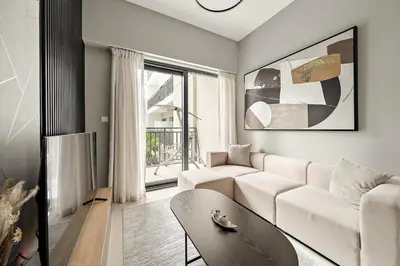 a living room with a white couch and a window at FIRST CLASS 1BR Modern Serenity in Dubai