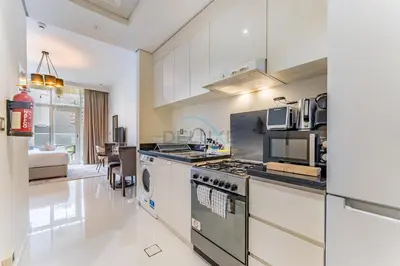 a kitchen with a stove and a microwave at Furnished Studio Near Circle Mall, Close to Parks, Jogging Tracks, Bus Stops And Grocery Stores - Damac Ghalia, JVC by Deluxe Holiday Homes in Dubai