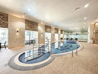 a lobby with a glass staircase in a building at Luxury 2BR in Dubai Marina Balcony, Views, Walk to Metro & Tram in Dubai