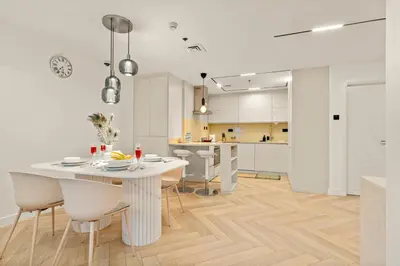 a kitchen and dining room with a white table and chairs at Luxury 2BR in Dubai Marina Balcony, Views, Walk to Metro & Tram in Dubai