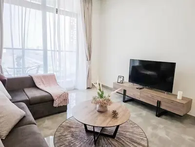 a living room with a couch and a flat screen tv at Southside Spacious & Sleek - 2BR in Dubai